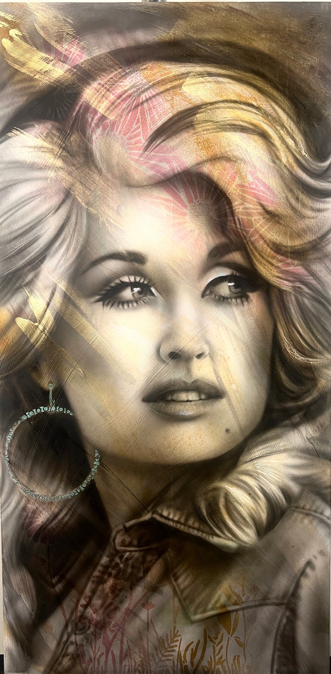 A mixed media painting on wood featuring a portrait of Dolly Parton with a blurred background.