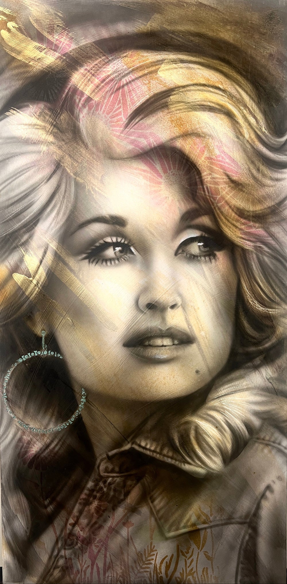A mixed media painting on wood featuring a portrait of Dolly Parton with a blurred background.