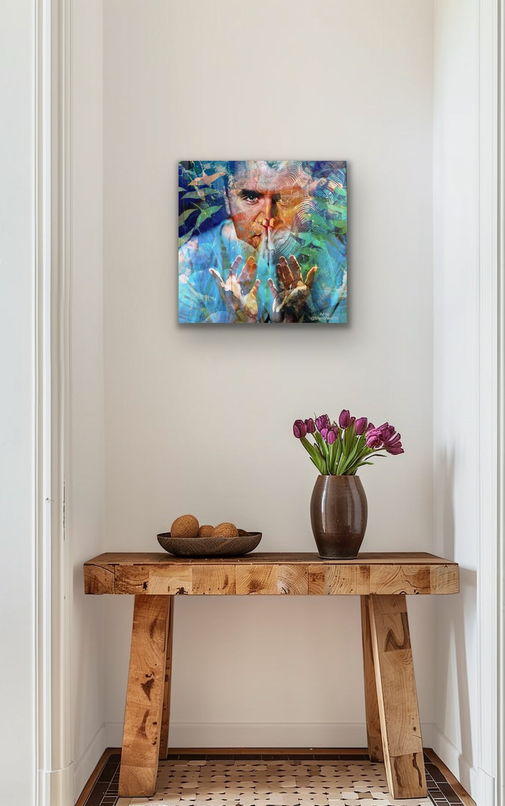 Artistic depiction of a man, charlie kirk, with a colorful background on a wall above a wooden console table with decorative items.