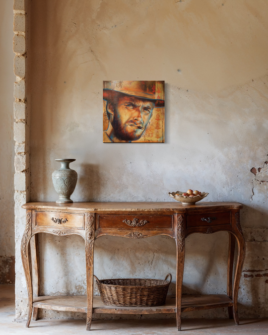Wooden console table with decorative items against a textured wall with a painting of a man in a hat. Clint Eastwood Giclée Canvas Reproduction — Limited Edition Fine Art Print by ShenShen