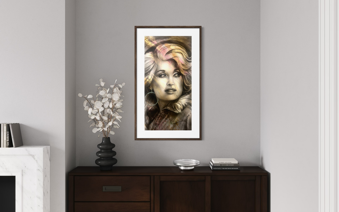 Framed artwork of a stylized portrait on a wall above a wooden cabinet.