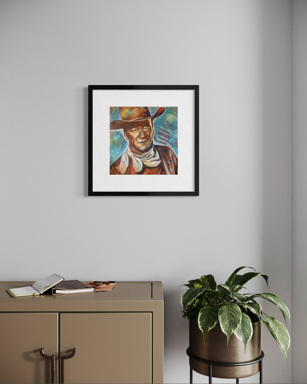 Framed artwork of a person wearing a cowboy hat on a wall above a cabinet with a plant. John Wayne fine art reproduction limited edition paper print by shenshen.