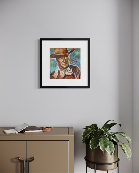 Framed artwork of a person wearing a cowboy hat on a wall above a cabinet with a plant. John Wayne fine art reproduction limited edition paper print by shenshen.