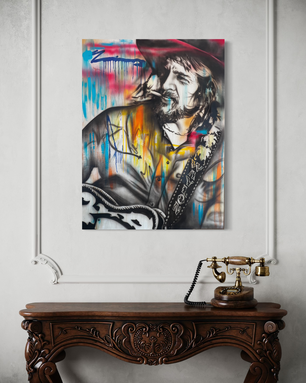 Colorful painting of a person with a hat on a wall above a wooden console table with a vintage phone. Waylon Jennings limited edition reproduction fine art print by ShenShen.